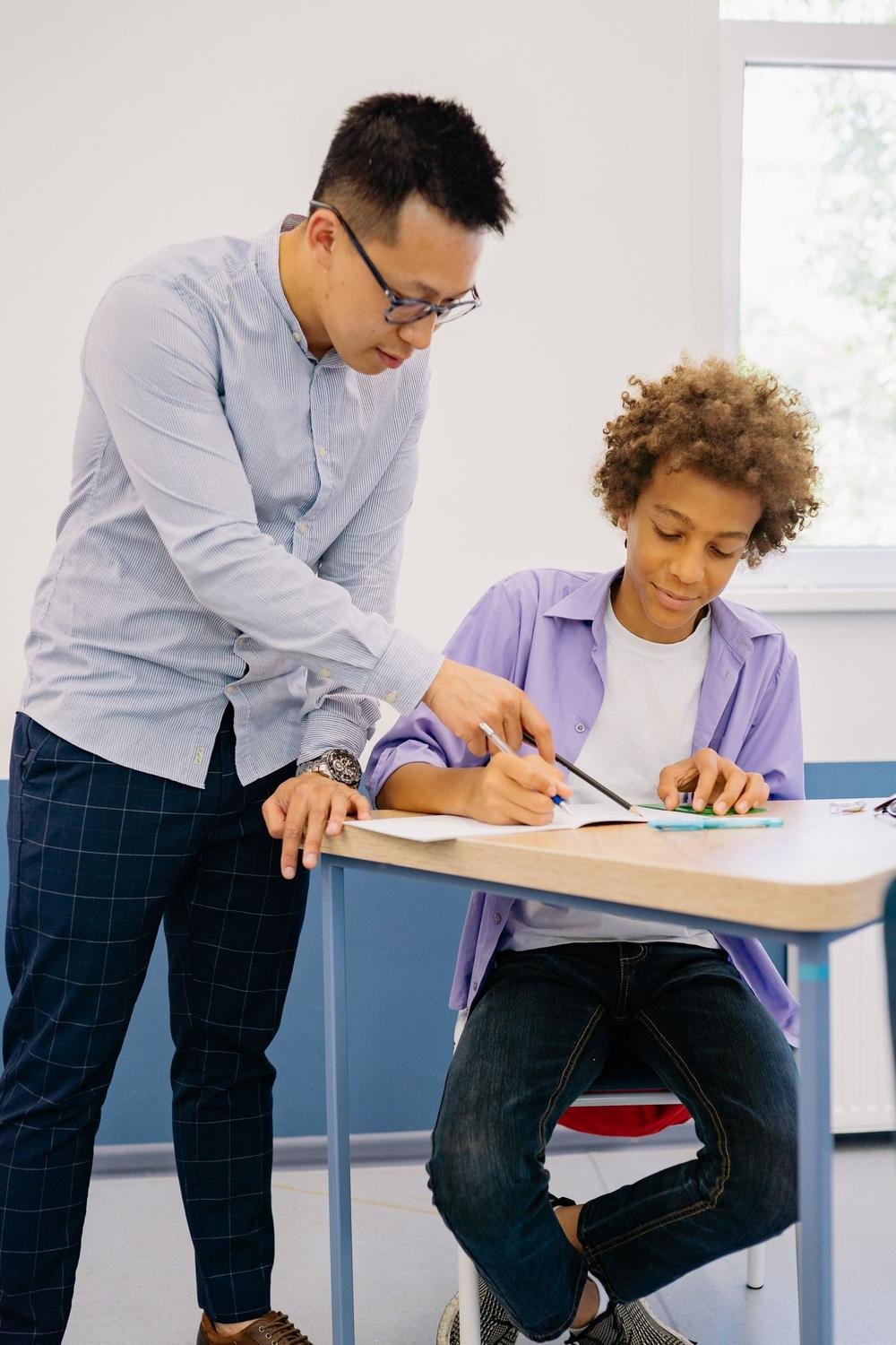 A teacher guiding a pupil