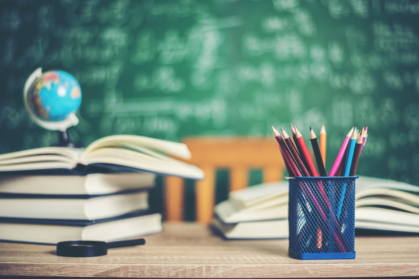 books and pencils with green whiteboard background