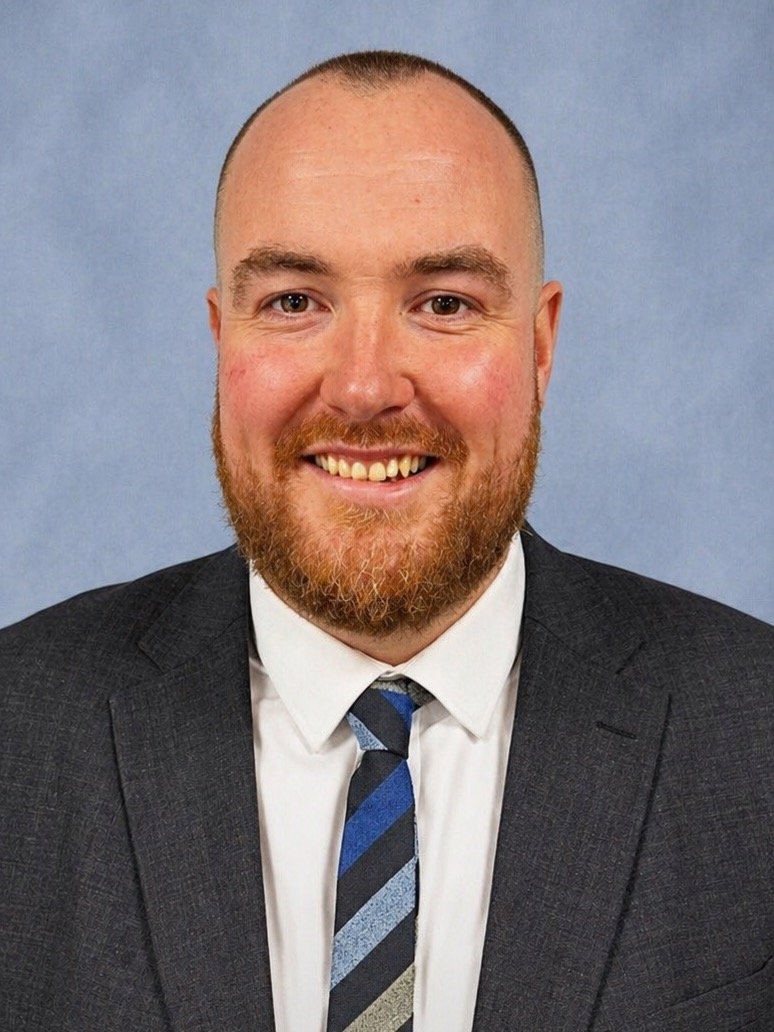 Professional headshot of Sam Gray